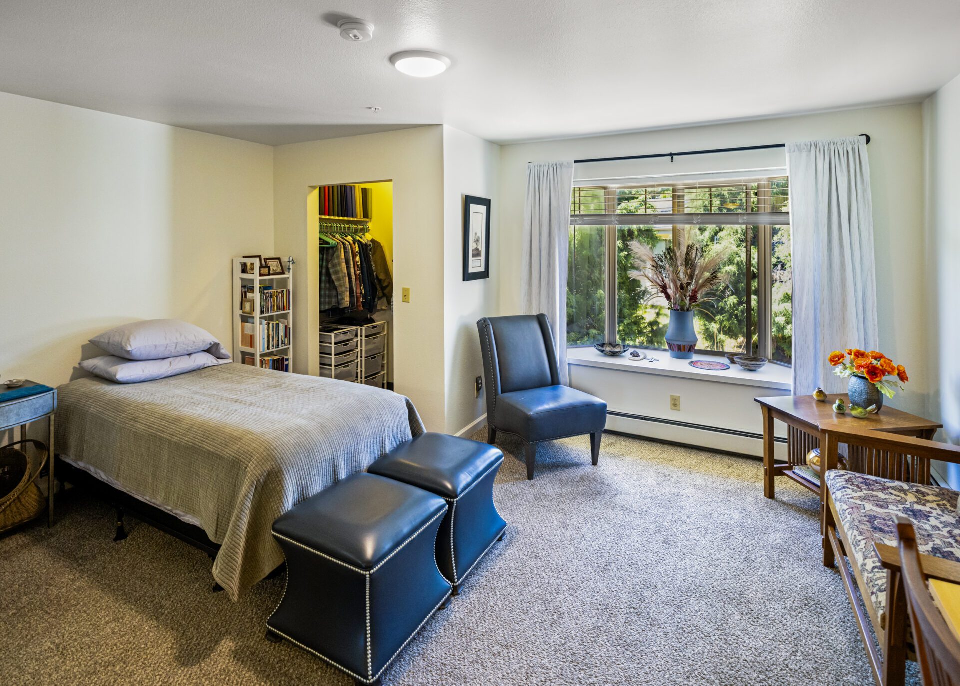 Cozy Bedroom Featuring A Large Window And Dresser